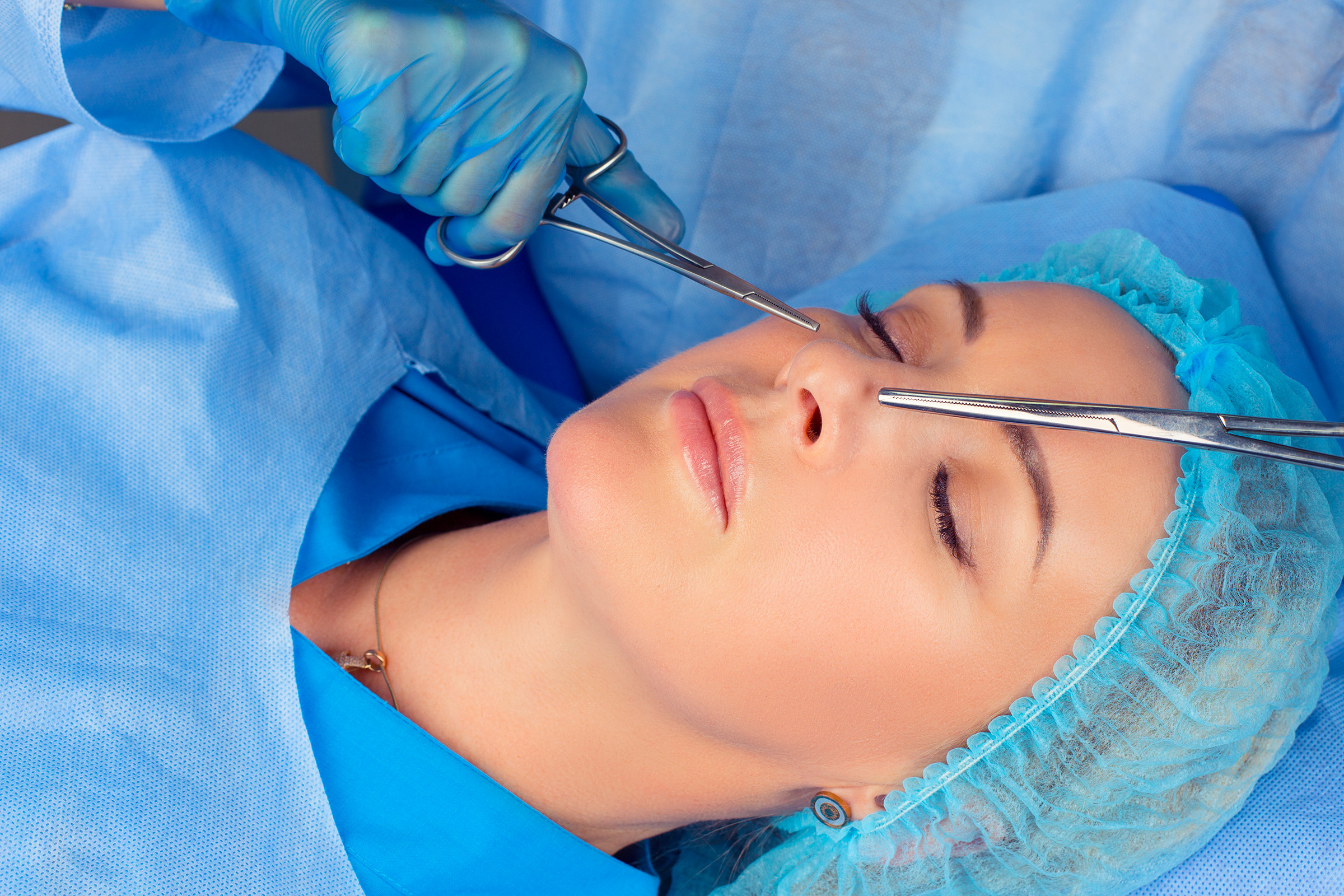 woman in surgical wear getting nose surgery