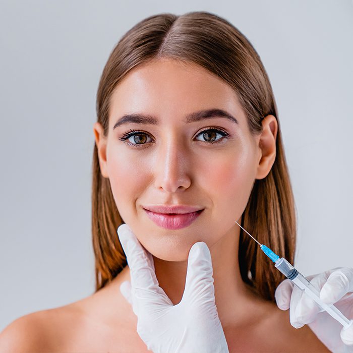 hands putting injectables on womans face