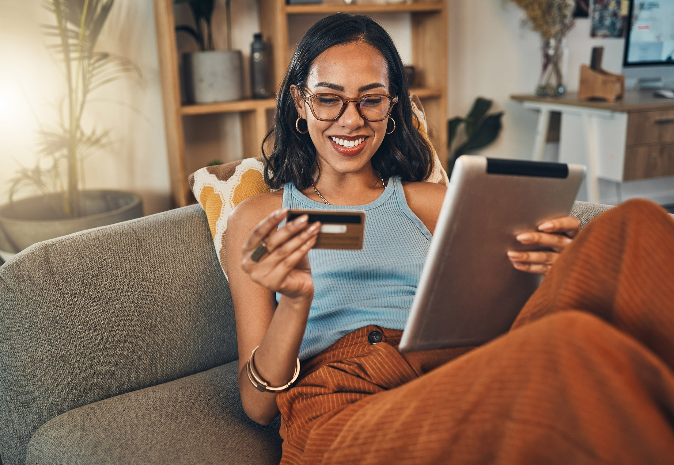 woman looking at card and making purchase online